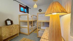 a room with two bunk beds and a lamp at Blue Tizirin House in Tamraght Ouzdar
