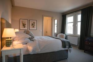 a bedroom with a bed and a table with a lamp at Drumornie in Brora