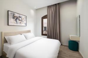 a bedroom with a white bed and a window at Sleep Inn Apart-Hotel in Cairo