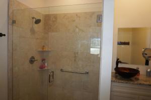 a bathroom with a glass shower with a sink at Lavender in Wimberley