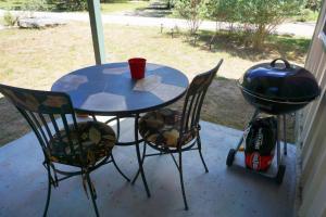 a table and two chairs and a grill on a porch at Lavender in Wimberley