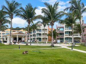 a park with palm trees in front of a building at Haudimar Beach Apt Ocean Front With Parking in San Antonio