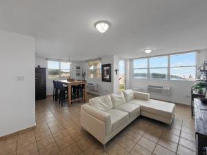 a living room with a white couch and a table at Haudimar Beach Apt Ocean Front With Parking in San Antonio