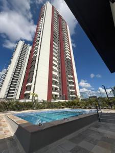 a building with a swimming pool in front of a building at Ap Studio Premium luxuoso novíssimo! in Sorocaba