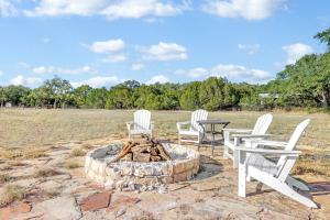 a group of white chairs around a fire pit at Lawlis Lodge in Wimberley