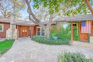 a brick house with a tree and a driveway at Lawlis Lodge in Wimberley