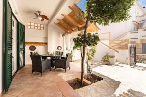 a patio with a table and chairs and a tree at Apartment Zdravko near centar in Novalja