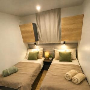 two beds in a small room with a window at Summer Stay - Mobile Home in Biograd na Moru