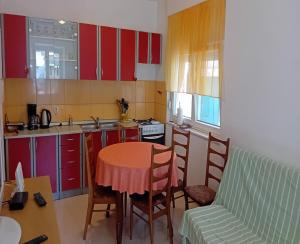 a kitchen with a table and chairs and a couch at House Veli Iz oldtown in Veli Iž