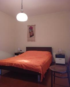 a bedroom with a bed with a orange bedspread at House Veli Iz oldtown in Veli Iž