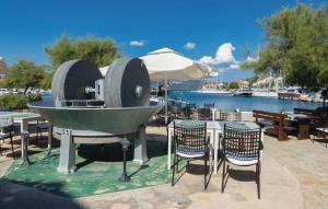 a table with chairs and an outdoor grill with a table and chairsktop at House Veli Iz oldtown in Veli Iž