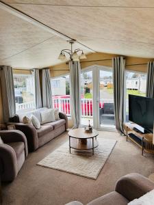 a living room with a couch and a tv at Edinburgh Lux Lodge Seton Sands in Port Seton