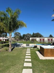 a park with a palm tree and a swimming pool at Complejo Aquiles in Lobos