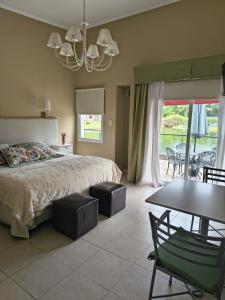 a bedroom with a bed and a table and chairs at Complejo Aquiles in Lobos