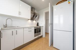 a kitchen with white cabinets and a refrigerator at Hauzify I Apartament Esmeralda in L'Ametlla de Mar