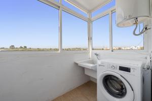 a laundry room with a washing machine and a sink at Hauzify I Apartament Esmeralda in L'Ametlla de Mar +13 photos