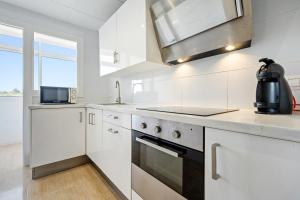 a white kitchen with a sink and a stove at Hauzify I Apartament Esmeralda in L'Ametlla de Mar
