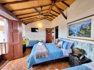 a bedroom with a bed and a ceiling fan at AQUI ESTOY BIEN in Barichara