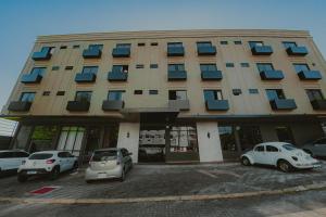a large building with cars parked in front of it at Zagat Classic Hotel in Foz do Iguaçu