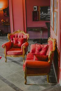 two red chairs and a table in a room at Zagat Classic Hotel in Foz do Iguaçu
