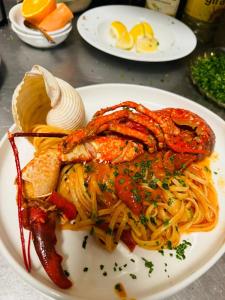a plate of food with seafood and pasta on a table at Sea Pearl Suite in Catania
