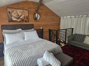 a bedroom with a bed and a chair and a couch at Casa Aconchegante in Pomerode