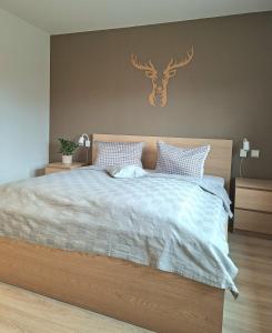 a bedroom with a bed with a deer head on the wall at Ferienhaus Wasserkunst in Wernigerode