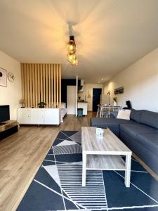 a living room with a couch and a table at Studio Cosy in Mimizan-Plage