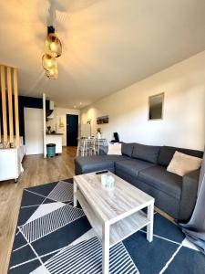 a living room with a couch and a table at Studio Cosy in Mimizan-Plage