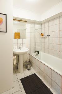 a bathroom with a sink and a toilet and a tub and a sink at Le Carnot Garden in Étampes +21 photos
