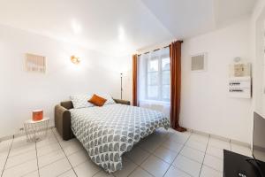 a white bedroom with a bed and a window at Le Carnot Garden in Étampes