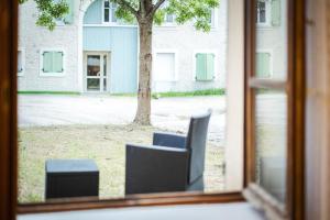 a window with two chairs in front of a building at Le Carnot Garden in Étampes