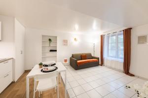 a living room with a couch and a table at Le Carnot Garden in Étampes
