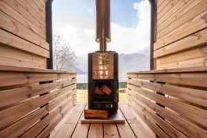 a woodburning stove in a room with a window at Villa Ledro with Private Dock - Sauna - Hot Tub in Molina di Ledro