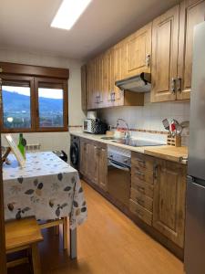 a kitchen with wooden cabinets and a table in it at Alojamiento Finca La Campa in Mareo de Abajo