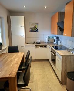 a kitchen with a wooden table and a wooden table and chairs at Ferienhaus Wasserkunst in Wernigerode