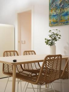 a table with chairs and a vase with a plant at Maison Begani66 in Gaeta
