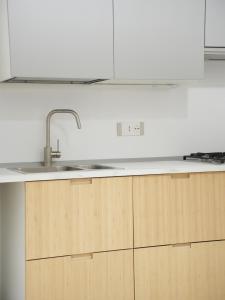 a kitchen with a sink and wooden cabinets at Maison Begani66 in Gaeta