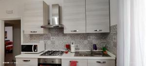 a kitchen with a sink and a microwave at Joly's Home in Luco neʼ Marsi
