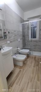 a bathroom with two sinks and a toilet and a shower at Joly's Home in Luco neʼ Marsi
