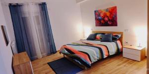a bedroom with a bed and a painting on the wall at Joly's Home in Luco neʼ Marsi +2 photos