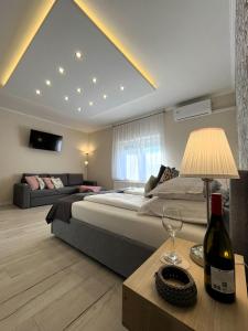 a bedroom with a bed and a table with a bottle of wine at Milano Vendégház in Bakonybél