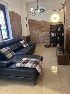 a living room with a black leather couch at Casa Balcones in Sahagún +22 photos