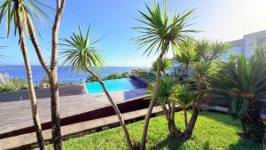 a villa with a swimming pool and palm trees at Marina Mar II - Moradia T3 in Vila Franca do Campo
