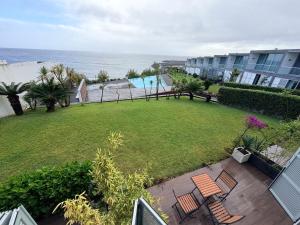 an aerial view of a yard with chairs and the ocean at Marina Mar II - Moradia T3 in Vila Franca do Campo