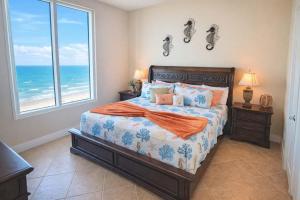 a bedroom with a bed with a view of the ocean at Sapphire 1706 home in South Padre Island