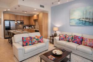 a living room with two couches and a kitchen at Sapphire 1706 home in South Padre Island