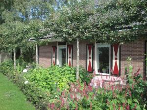 una casa de ladrillo con cruces rojas y blancas en las ventanas en Achterhuis Hamingen, en Staphorst