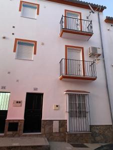 a white building with windows and balconies at Apartamento Tarramilla in Prado del Rey