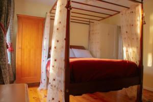 a bedroom with a bed with red sheets and curtains at Cooperstown Bed and Breakfast in Cooperstown